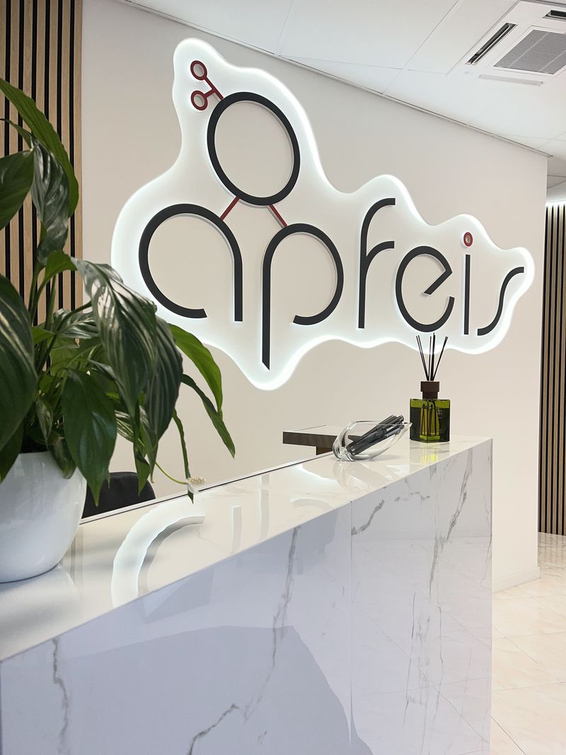 La reception della sede Apfeis a San Donà di Piave, con l'insegna del logo illuminata sopra il bancone in marmo